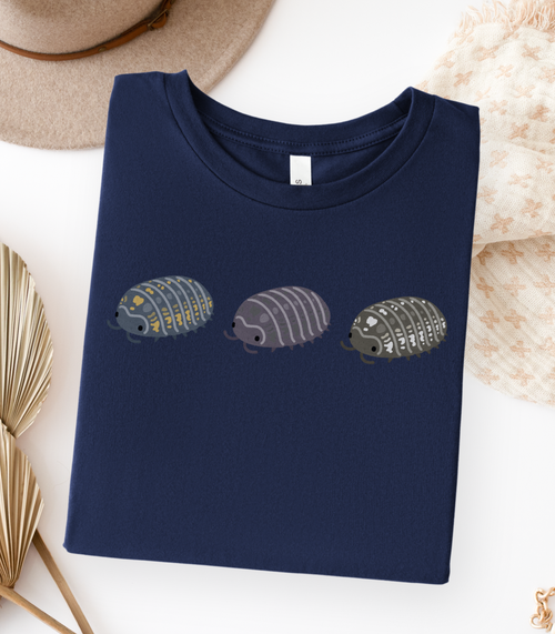 A folded navy blue t-shirt with a graphic of three stylized isopods in blue and yellow, purple, and black and white.